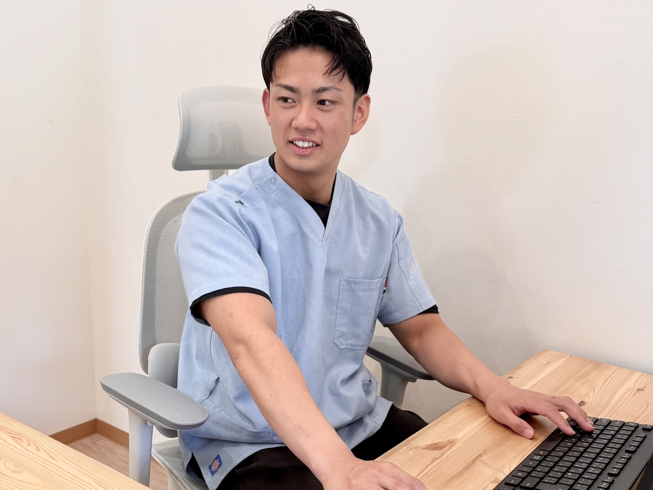 「木の温もりある受付カウンターで次回予約を案内する清潔な空間（上福岡みつばち美容整骨院）」