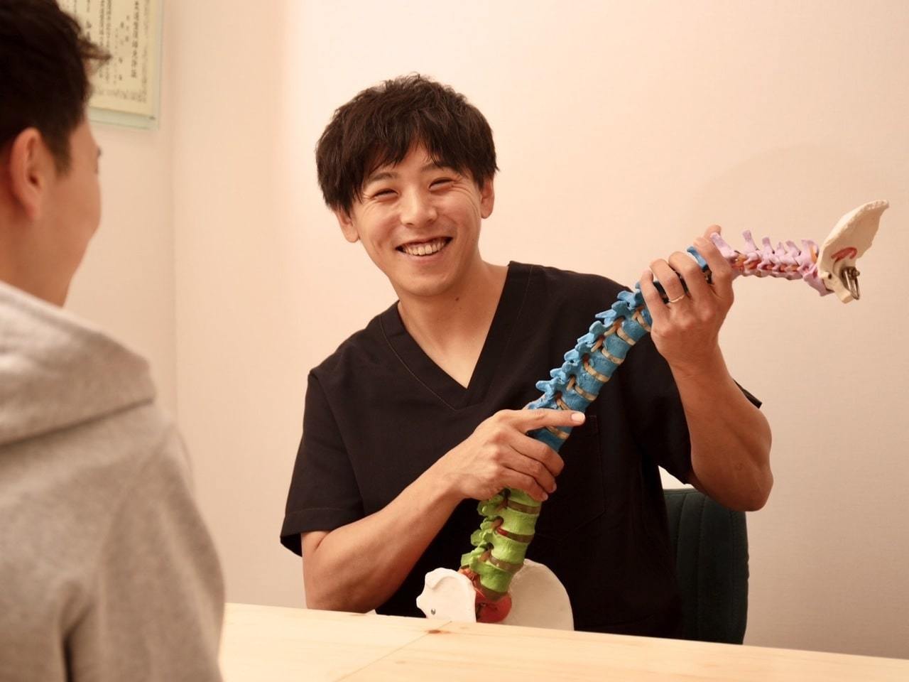 「施術後の体の変化を確認しながら姿勢やセルフケア方法を丁寧に説明する様子（上福岡みつばち美容整骨院）」